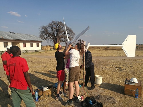 Four people assembling a small wind turbine in rural Tanzania