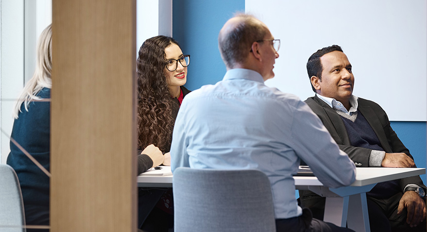 Four persons in a meeting room 